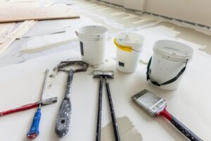 home renovation construction indoor shot with tools paint buckets primer jerry can white floor