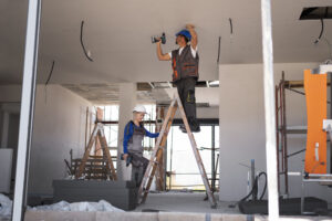 full shot man woman standing ladder