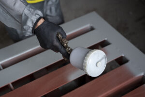 high angle worker spraying powder paint from gun