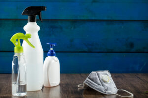 medical mask with hand sanitizers around white containers