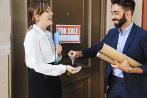 real estate agent giving key woman