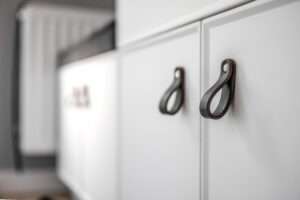 close up minimalistic white furniture with black handles kitchen cabinet details