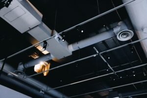 low angle shot metal black ceiling with white ventilation pipes