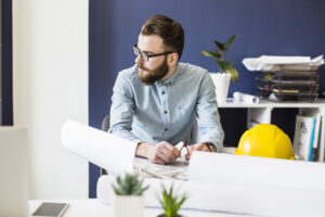 male engineer sitting workplace with architectural plan table