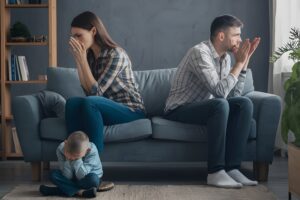 family is sitting couch baby is holding his hands