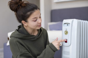 medium shot woman pushing heater s red button