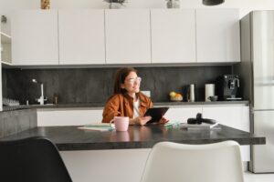 portrait young woman studying home girl reading something tablet sitting kitchen 1