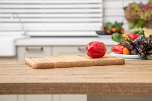 fresh red bell pepper wooden plank against background kitchen interior