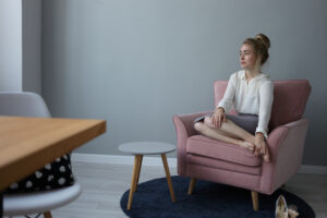 indoor shot beautiful tired young european businesswoman with messy hairstyle sitting barefooted comfortable armchair wearing formal office clothes relaxing after work massaging her feet