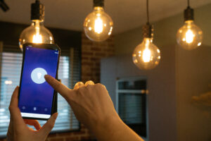 smart home hand controlling smart lamps with app phone electric concept